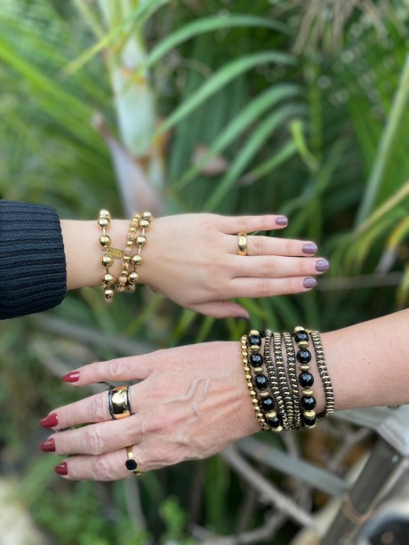 על היד מימין צמיד חרוזים שחור וזהב , צמידי זהב וטבעות זהב מאיה אהרוני תכשיטים 