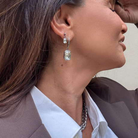 בחור הראשון אני עונדת עגיל כסוף קריסטל מלבני שטוח בגוון שקוף