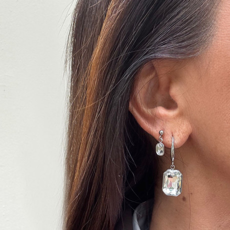 בחור הראשון אני עונדת עגיל כסוף קריסטל מלבני שטוח בגוון שקוף