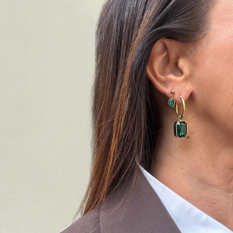 בחור הראשון אני עונדת זוג עגילי חישוק בציפוי זהב עם זירקון מלבני רחב בגוון ירוק